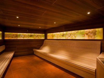 Gemütliche Sauna mit holzverkleideten Wänden, langen Sitzbänken und indirekter Beleuchtung.