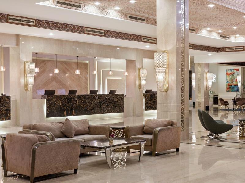 Jasne, eleganckie lobby hotelowe z nowoczesnymi miejscami do siedzenia i lśniącą marmurową podłogą.