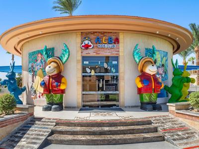 Round building with colorful decorative figures and palm trees in a sunny outdoor area.