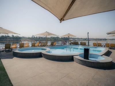 Moderne jacuzzi-ruimte met parasols en ligstoelen bij helder daglicht.