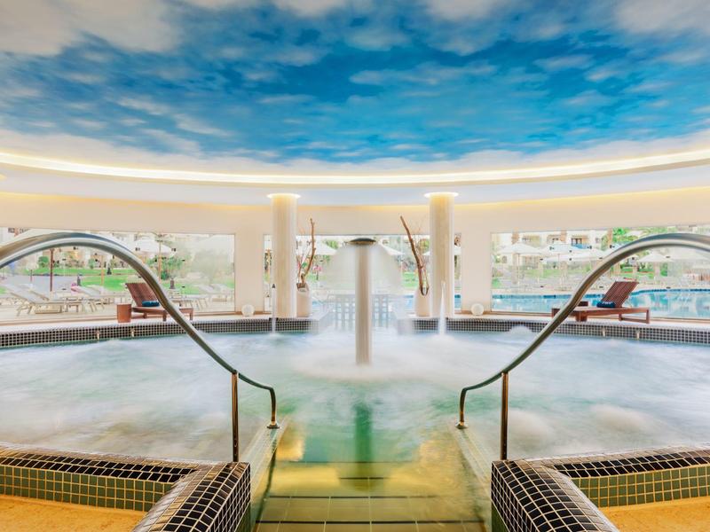 Modern binnenzwembad met jacuzzi en plafond met hemelmotief in een hotel