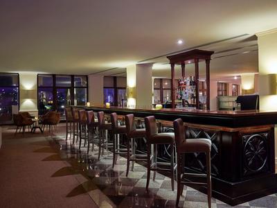 Elegant hotel bar with leather seats and soft lighting at night.