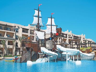 Waterpark met piratenschip en glijbanen voor een meerlaagse hotel bij heldere lucht