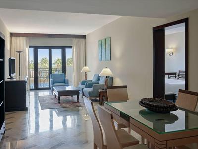 Helles Wohnzimmer mit Glastisch, Sofa und Balkon mit Meerblick