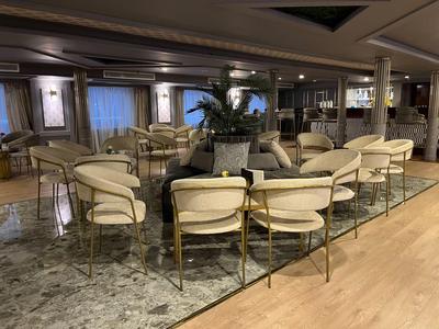 Een uitnodigende, moderne hotel lounge met crèmekleurige stoelen en planten.