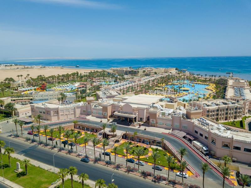 Großer Strandresort-Komplex am Meer mit Pools, Sandstrand und blauen Himmel.