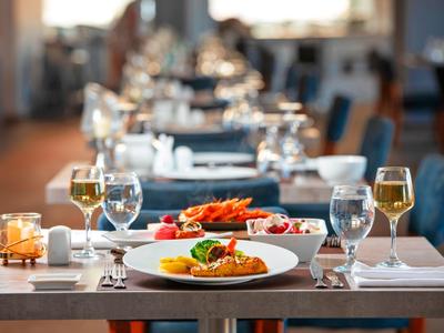 Elegante restauranttafel gedekt met gourmetgerechten en wijnglazen, klaar om te dineren.