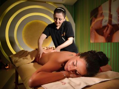 Femme recevant un massage relaxant dans une salle de spa moderne.