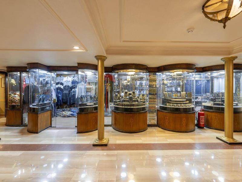 Museum room with glass display cases featuring various artifacts and a polished floor.