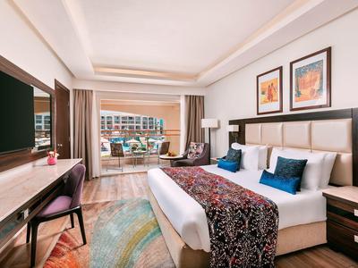 Chambre d'hôtel moderne avec lit double, télévision, terrasse et vue sur la ville.