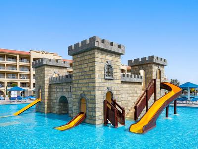 Parc aquatique avec toboggans en forme de tour de château dans une piscine d'hôtel sous un ciel dégagé