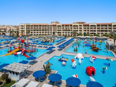 Grand hôtel avec plusieurs piscines et aire de jeux colorée pour enfants en extérieur.