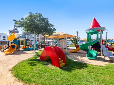 Parque infantil con toboganes y estructuras para escalar en un día soleado en un parque.