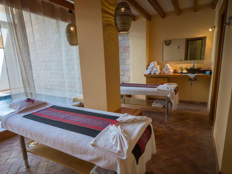 Accogliente sala benessere con due lettini da massaggio e illuminazione calda.