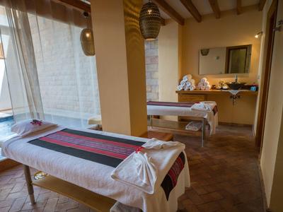 Accogliente sala benessere con due lettini da massaggio e illuminazione calda.