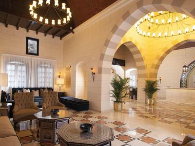 Eleganter Hotellobby mit Säulen, gemütlichen Sitzgelegenheiten und warmem Licht.