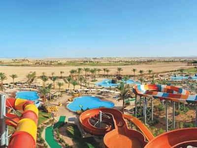 Colorful water park with water slides and palm trees in a desert landscape under blue sky