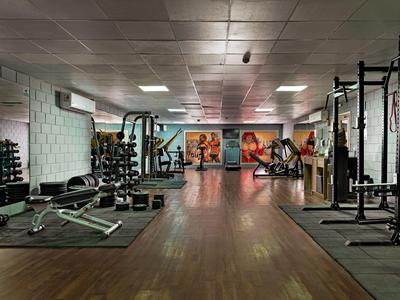 Modern gym with dumbbells, benches, and equipment in a hotel.