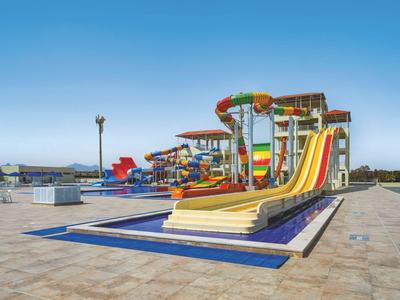 Kleurrijke waterglijbanen in een waterpark onder een heldere blauwe lucht