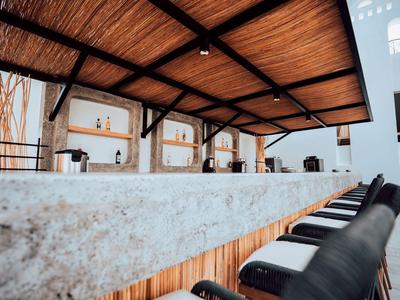 Moderní venkovní prostor s barovými židlemi a zastřešeným pultem v hotelu