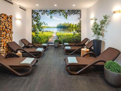 Ontspanningsruimte met bruine ligstoelen, witte handdoeken en een landschapsschilderij aan de muur.