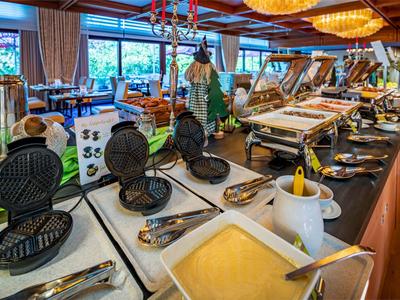 Binnenzicht van een buffet met wafelijzers, champagne en verschillende ontbijtgerechten.