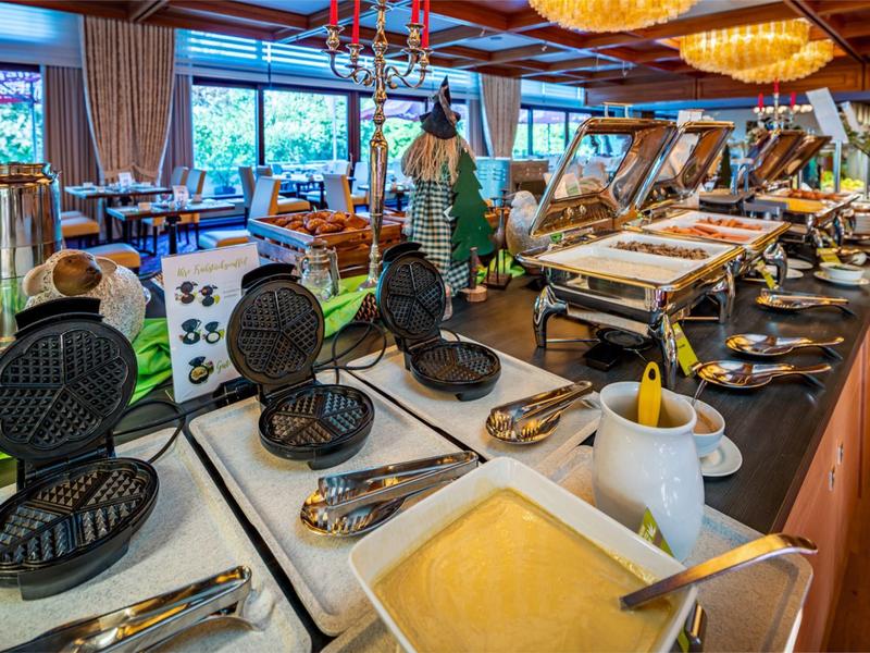 Binnenzicht van een buffet met wafelijzers, champagne en verschillende ontbijtgerechten.