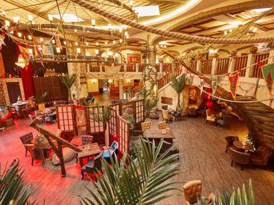 Luxuriöse Hotellobby mit rustikalem Design, Holzmöbeln und bunter Dekoration.