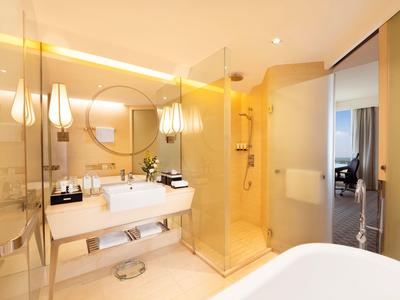 Helles Badezimmer mit großen Spiegeln, Doppelwaschbecken, Glasdusche und moderner Beleuchtung.