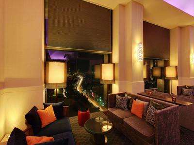 Gemütlicher Wohnzimmerbereich mit Sofas, Kissen und warmem Licht in abendlicher Atmosphäre.