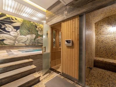 Moderne wellnessruimte met sauna, trap en decoratief wandontwerp.