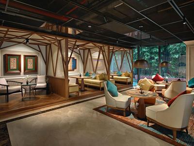 Espace lounge d'hôtel moderne avec fauteuils confortables et accents en bois.