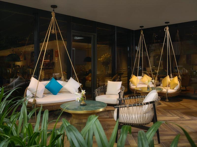 Chaises suspendues modernes et sièges confortables sur une terrasse couverte avec des plantes.