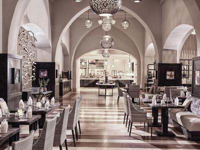 Ristorante elegante in hotel con soffitti a volta, tavoli ordinati e lampade decorative sospese.