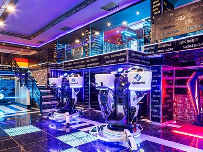 Sala de juegos VR moderna con luces de neón y estaciones de juego futuristas.