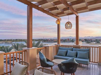 Terrasse mit modernem Sitzbereich und Aussicht auf Stadt und Berge bei Sonnenuntergang