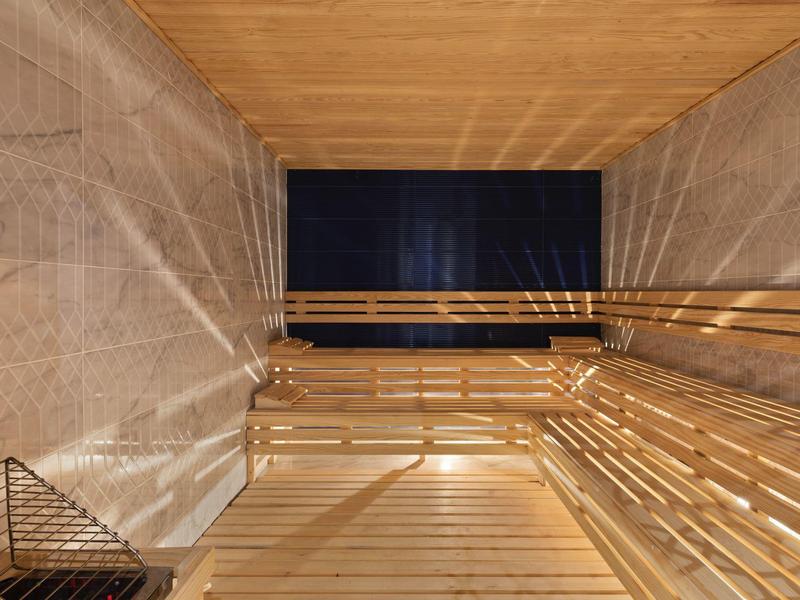 Interno di sauna con panche in legno e pareti in pietra.