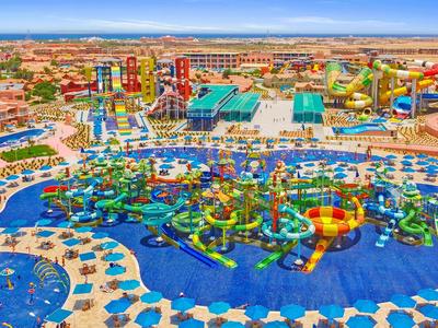 Duży park wodny z zjeżdżalniami, basenami i kolorowymi atrakcjami wodnymi w słonecznym otoczeniu.