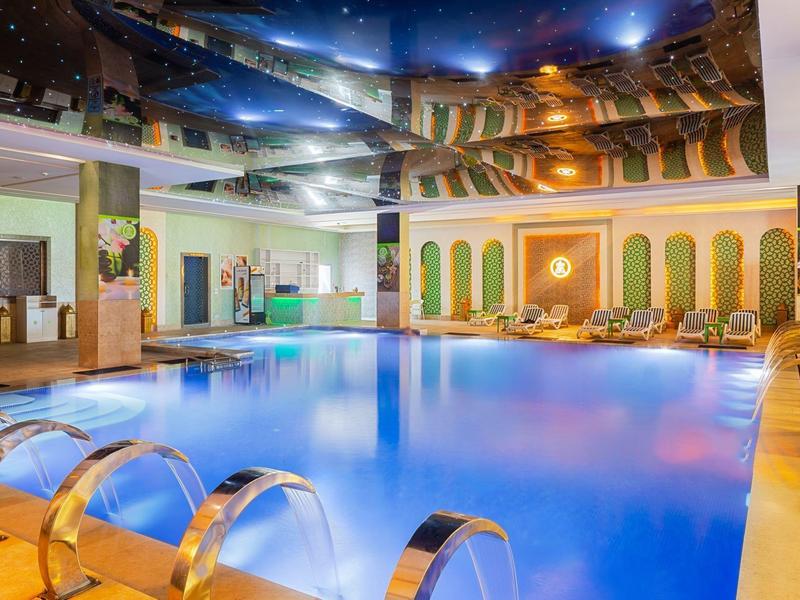 Piscina interna in un hotel moderno con comodi lettini e illuminazione luminosa