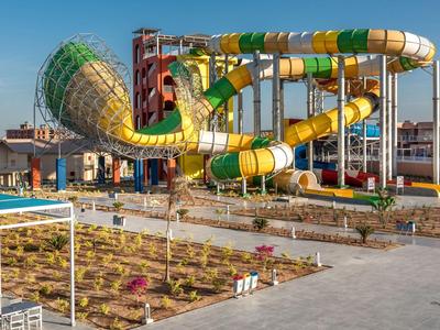 Bunte Wasserrutschen in einem Außenbereich eines Hotels bei klarem Himmel.