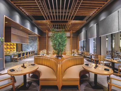 Modernes Restaurant mit Holzdecke, bequemen Sitzbänken und großen Fenstern