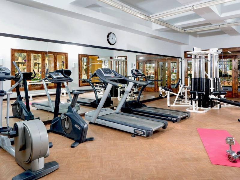 Fitnessraum mit Laufbändern, Fahrrädern und Gewichten in einem Hotel.