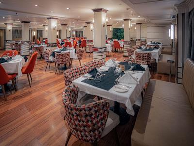 Elegancka restauracja z nakrytymi stołami, wygodnymi krzesłami i drewnianą podłogą.