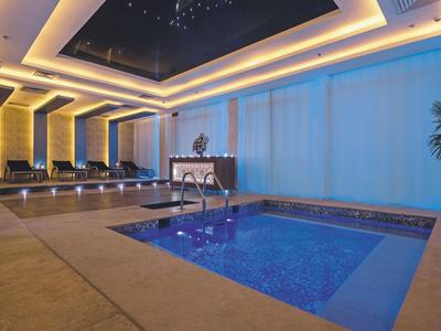 Modernes Hallenbad mit warmem Licht und Sternenhimmel an der Decke