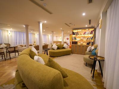 Accogliente zona lounge dell'hotel con posti a sedere comodi e illuminazione calda.