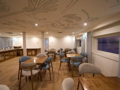 Gezellige eetkamer met houten meubels en subtiel muurpatroon.