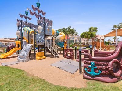 A colorful outdoor playground with climbing structures and slides under clear skies.