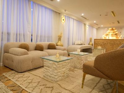 Gezellige hotel lounge met comfortabele banken, tapijt en zachte verlichting.