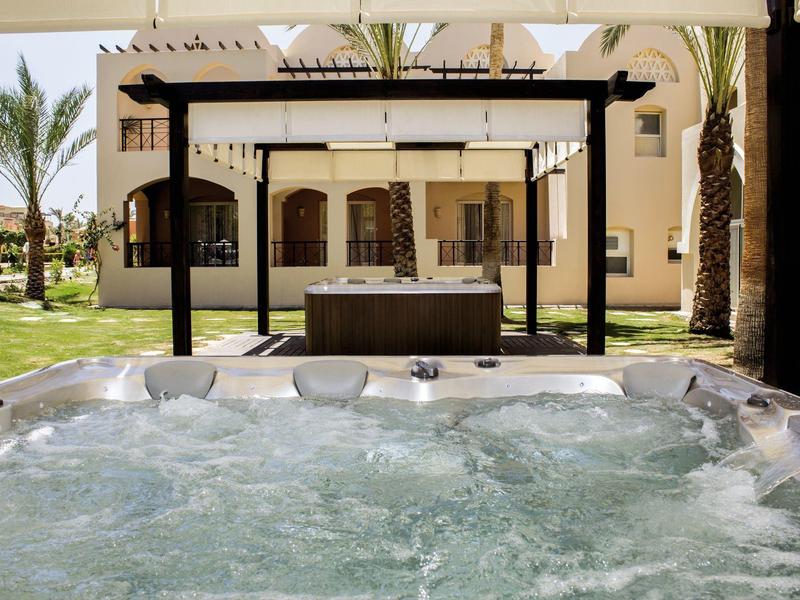 Parco acquatico con scivoli a forma di nave pirata in piscina bassa, cielo limpido.