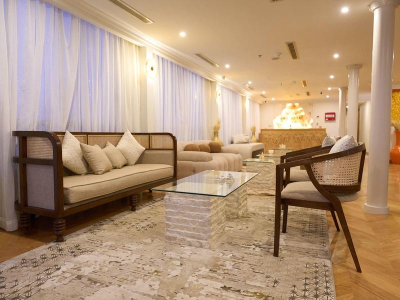 Helles, modernes Wohnzimmer mit mehreren Sitzbereichen, Teppichboden und Glas-Couchtisch.